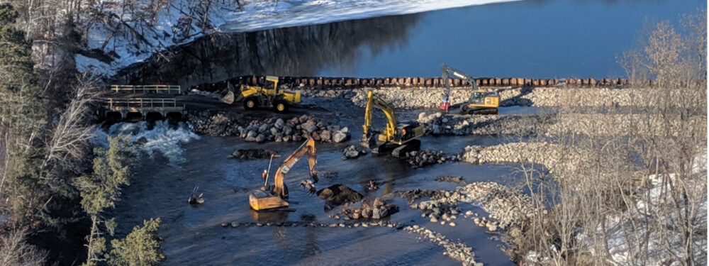construction trucks dredging a river
